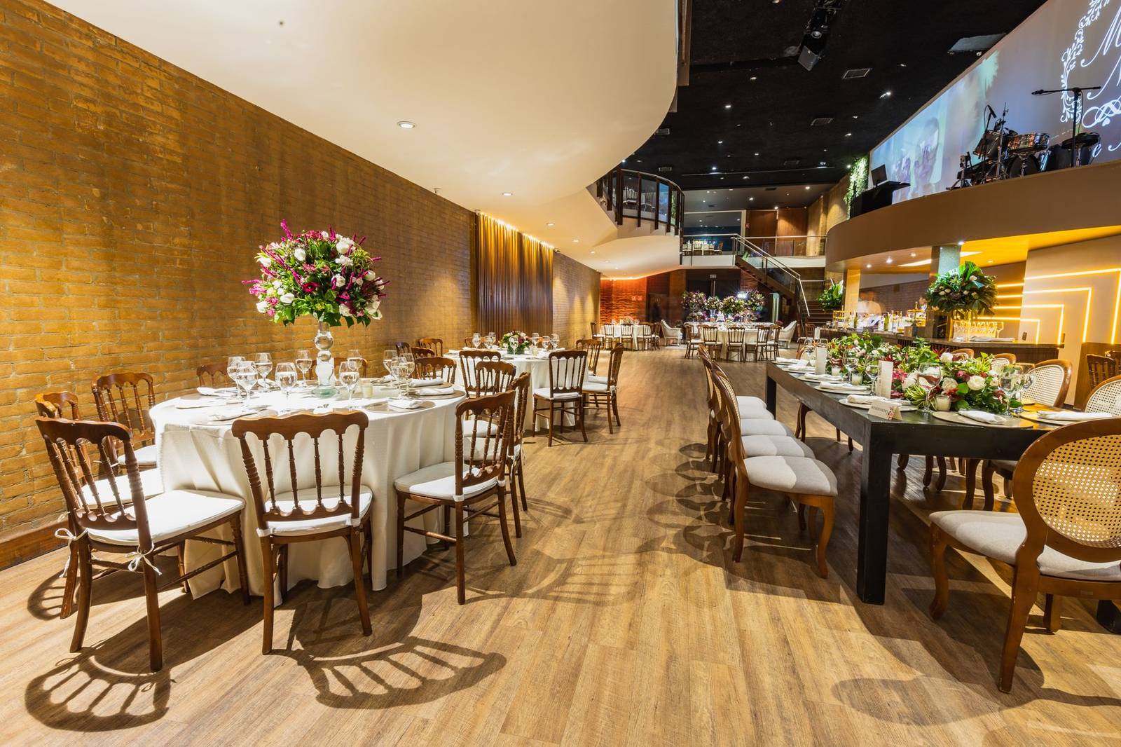Luxurious wedding hall set for a reception with elegant table arrangements and floral decor.