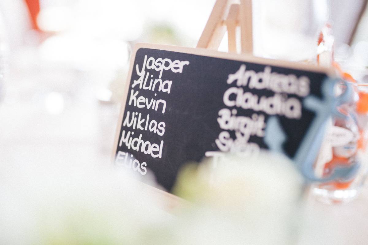 A decorative chalkboard displaying names at a refined indoor gathering.