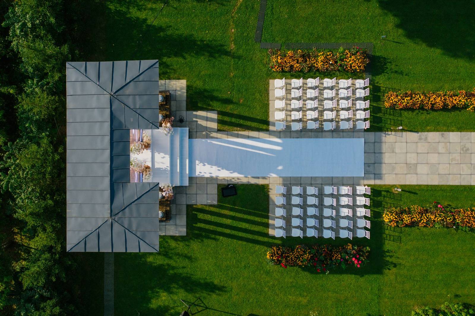 Drone shot of beautifully prepared outdoor wedding venue with chairs and gazebo.