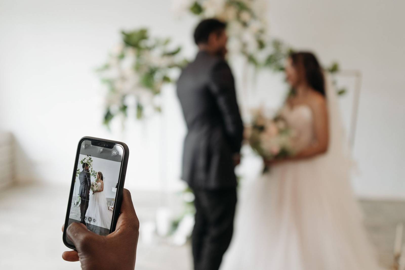 A smartphone captures a couple during their wedding ceremony, highlighting modern traditions.